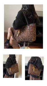 Detail of vintage leopard print tote bag with black leather straps and beaded charm