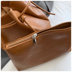 Detail eines braunen PU-Leder-Taschen-Sets mit Faltenstruktur und Innenbeutel-Reißverschluss