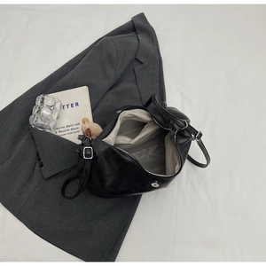 Interno della borsa tote in PU nero con fodera grigia, tasche e ciondolo a pompon