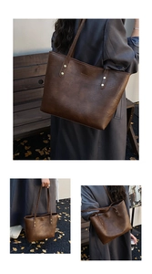 Detail of dark brown tote bag featuring retro gold rivets and textured leather finish