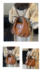 Dettaglio macro dello zaino in pelle PU marrone con trama vintage e ciondolo di peluche