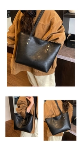 Detail of a large black tote bag with gold metal rivets and smooth wax leather texture