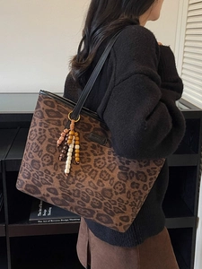 Grand sac cabas léopard avec pompon en perles de bois porté à l'épaule par un mannequin
