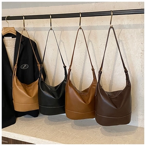 Reihe minimalistischer großer Softleder-Totes in Braun und Schwarz an Metallhaken