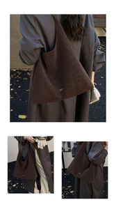Détail d'un cabas vintage en daim marron foncé avec lettrage doré et texture douce