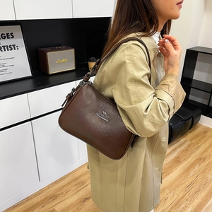 Detailed close-up of dark brown leather shoulder bag with metallic kangaroo logo