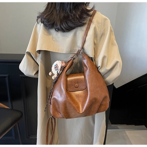 Dettaglio della borsa tote in pelle PU marrone con texture morbida e ciondolo a pecora