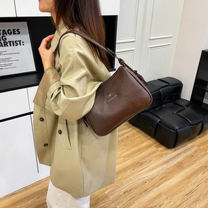 Detailed view of the dark brown leather texture and silver kangaroo logo on a shoulder bag