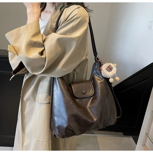 Dettaglio della borsa tote in pelle PU marrone con un simpatico ciondolo a pecorella