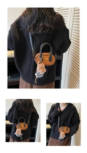 Dettagli della mini borsa baguette in pelle marrone con ciondolo a forma di orso