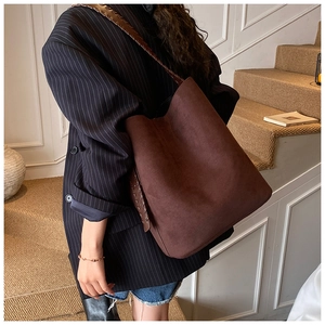 Detail of dark brown suede hobo bag with braided stitching shown on shoulder strap