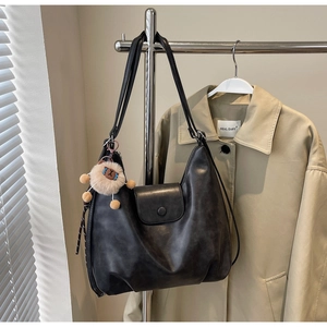 Dettaglio della borsa tote vintage in pelle PU nera con ciondolo a pecora e patta