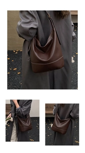 Detailansicht der dunkelbraunen Leder-Schultertasche mit weißen Kontrastnähten im Fokus