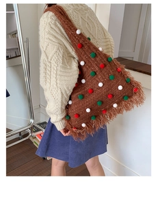 Brown Christmas tree knit tote bag with colorful pom-poms and fringe detail on model