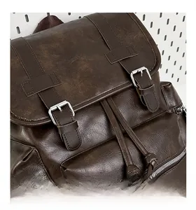 Detail of dark brown PU leather backpack showing vintage metal buckle and drawstring closure