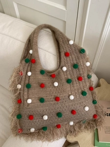 Brown knitted tote bag with colorful pom-poms and fringe tassels in Christmas style