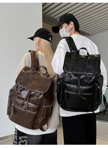 Detail view of large PU leather backpack featuring drawstring closure and multiple zip pockets