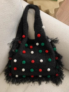 Chic black knitted tote bag with festive colored pom-poms and long fringe tassels
