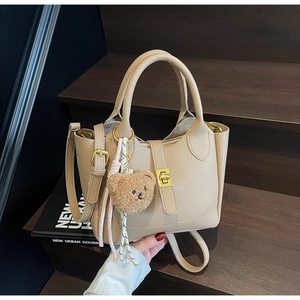 Sac seau beige motif litchi avec fermoir doré et pendentif ours brun en peluche