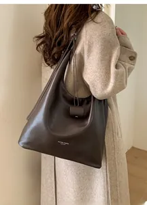 Grand sac cabas marron en cuir porté avec un manteau en cachemire beige chic