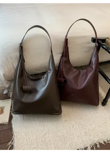 Détails de grands sacs cabas en cuir café et bordeaux avec une finition lisse