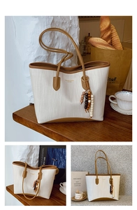 Detail of woven tote bag featuring brown leather trim and a wooden beaded tassel accent