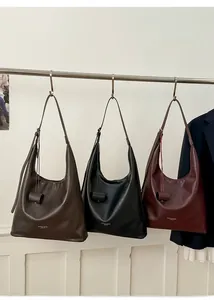 Gros plan de trois sacs hobo vintage en marron foncé, noir et rouge bordeaux