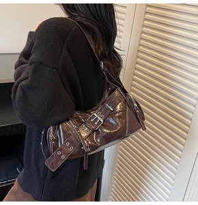 Vue détaillée du sac baguette en cuir verni marron foncé avec détails métalliques biker