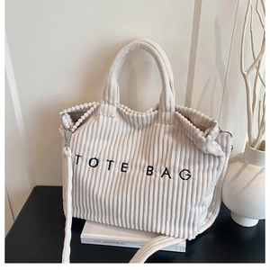 Close-up of the thick corduroy fabric and TOTE BAG embroidery on this white tote bag