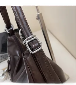 Macro shot of silver metal buckle and strap details on vintage brown leather tote bag