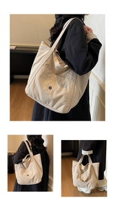 Close-up of beige canvas tote bag showing dual straps and front pocket detail