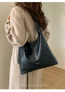 Close-up of minimalist black leather tote bag showing large capacity and soft texture