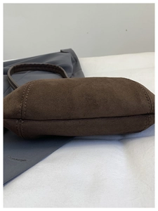 Detailed close-up showing the bottom and side stitching of this brown suede hobo bag