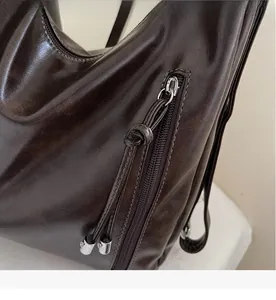 Detail of smooth metal zipper and brown leather knot puller on the retro tote bag