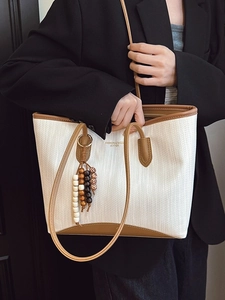 Chic cream woven tote bag with brown leather trim and colorful beaded charm detail