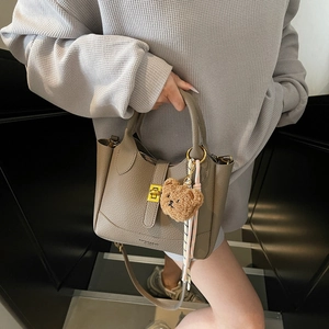 Sac seau à motif litchi gris-brun avec breloque ours et fermoir doré chic