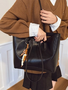 Fashionable black woven leather tote bag with colorful bead tassel and gold lettering