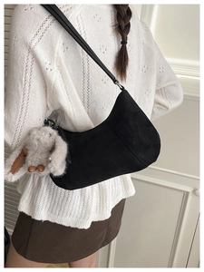 Detail of black matte suede hobo bag with a soft plush bunny charm accessory