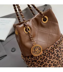 Detailed shot of dark brown quilted bucket bag with leopard print and gold metal charm