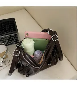 Top view of spacious interior of brown leather tote bag with daily essentials inside