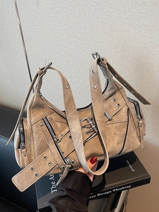 Sac baguette utilitaire rétro kaki avec zips et sangles à œillets sur des livres
