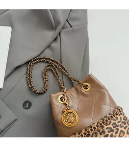 Detailed close-up of brown quilted bucket bag with leopard print and golden logo