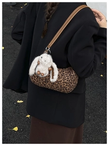 Detail of leopard print cylinder bag with leather strap and plush bunny charm