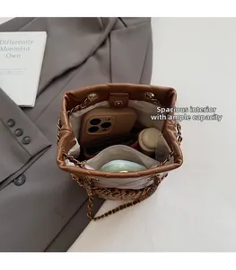 Interior view of brown quilted bucket bag with chain strap showing storage capacity