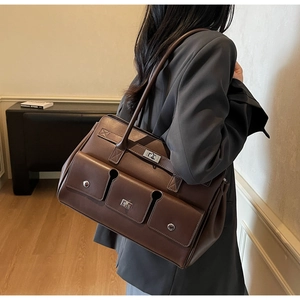 Brown vintage leather tote bag detail with three front pockets and silver twist lock