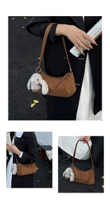 Detail of a brown suede moon bag with a white plush rabbit charm for autumn outfit