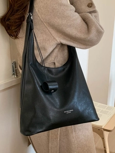 Minimalistische schwarze Leder-Einkaufstasche mit Schultergurt und zylindrischem Anhänger