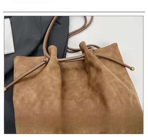Close-up of caramel retro tote bag showing frosted texture and gold sphere drawstring detail