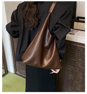 Brown soft leather hobo bag with litchi texture showing natural drape on shoulder