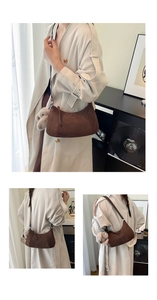 Detail of dark brown suede crescent bag with cute rabbit plush charm and shoulder strap